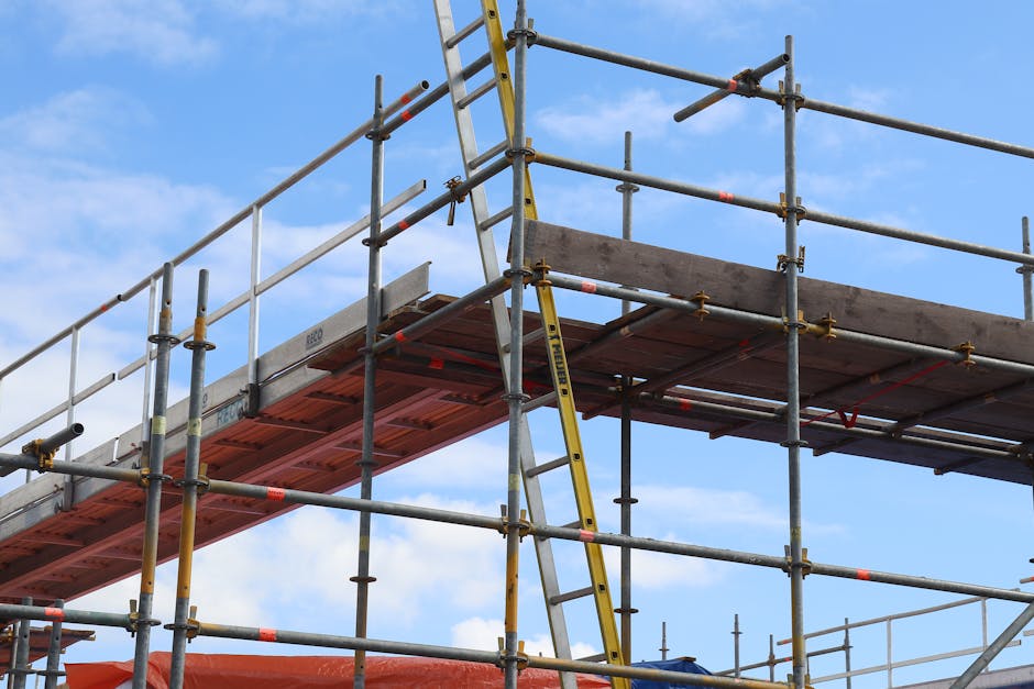 Detailed view of a construction site scaffolding structure and ladder against a bright blue sky