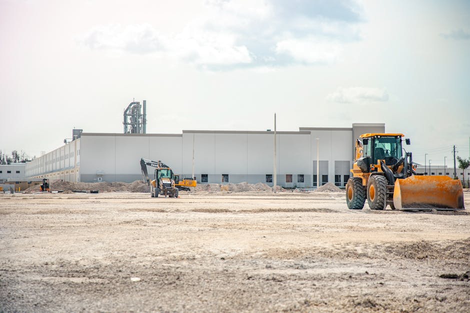 A large construction site featuring heavy machinery and industrial building in progress