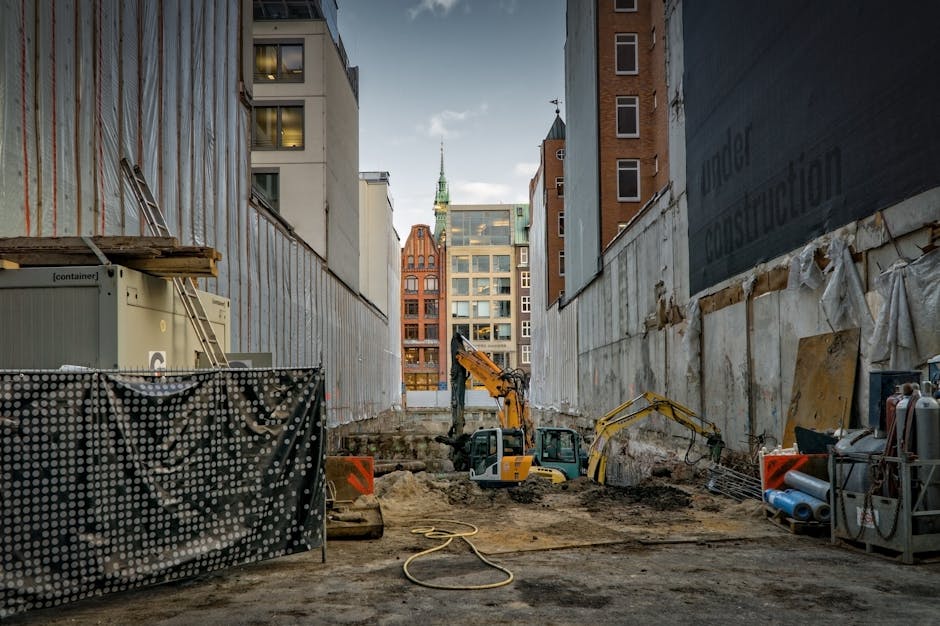 Construction site in an urban area with excavators and scaffolding, showcasing development
