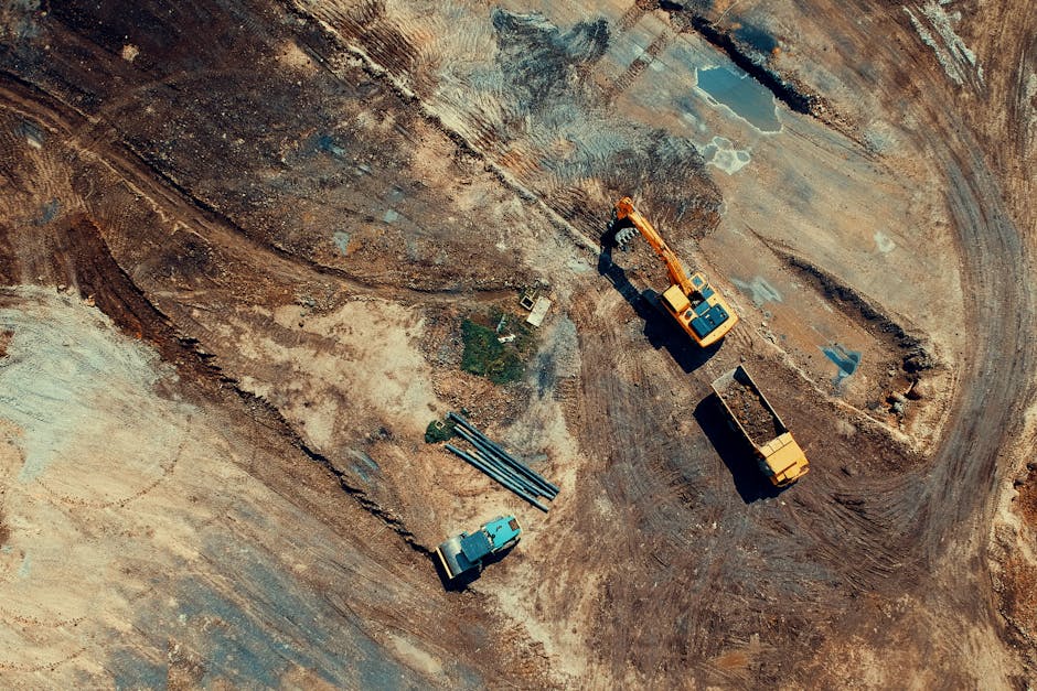 Aerial view of a construction site featuring heavy machinery and trucks, displaying industrial activity